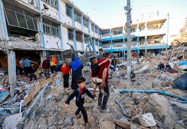 Palestinians check the destruction at a UNRWA school housing displaced people, following an Israeli strike in the Bureij refugee camp in the centre of the Gaza Strip, on May 7, 2025 (AFP photo) 